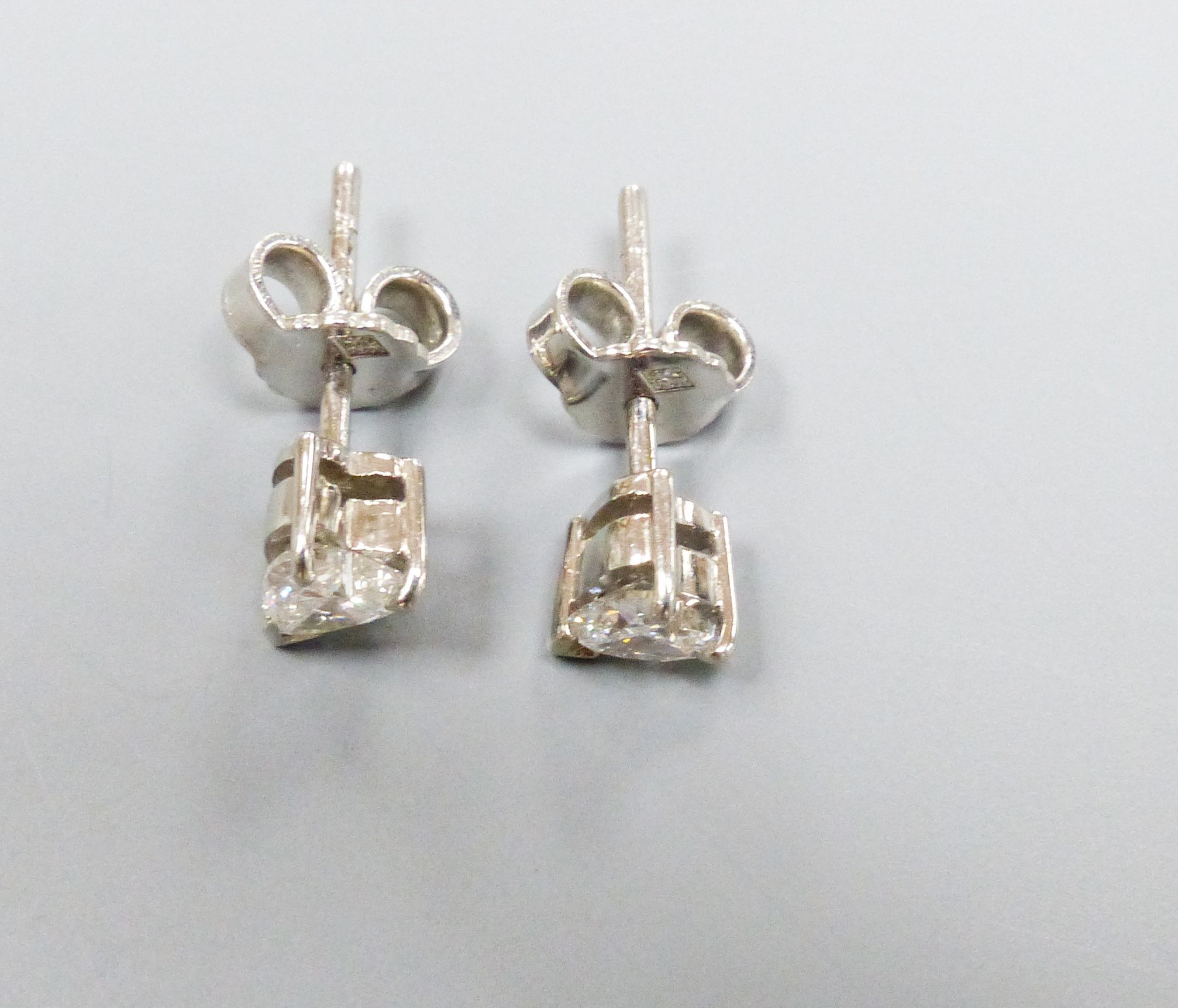 A pair of modern white metal and solitaire heart shaped diamond set ear studs, diameter approx. 5mm, gross weight 3.2 grams.